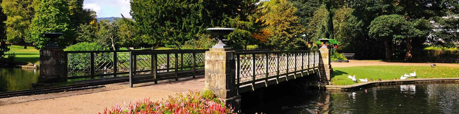 Footbridge across the lake in the Pavilion Gardens, Buxton, Peak District, Derbyshire