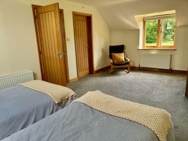 Other end of the twin bedroom showing doors to bathroom & Landing area