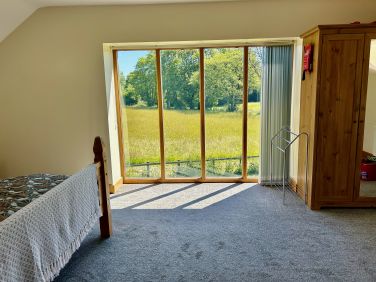 Floor to ceiling window in the main bedroom gives great views of the fields