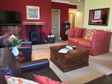 Spacious, comfortable lounge with woodburner