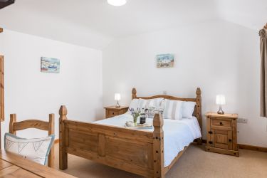 Spacious King size bed made up with fresh white linen on arrival