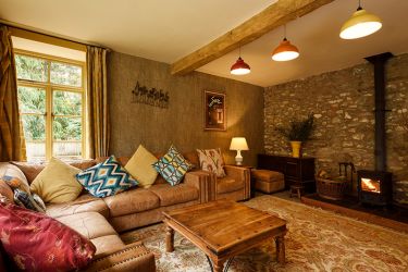 Comfy and cosy sitting room with log burner and large smart TV.