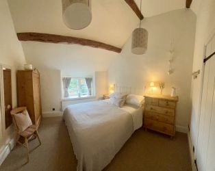Like the rest of the cottage, the bedroom has lots of character and charm