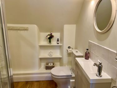 Pretty little ensuite with shower, WC, vanity basin and heated towel rail