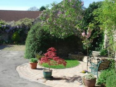 Walled guests' garden area with parking space