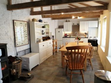 Wood burner in the spacious kitchen with wood supplied