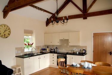 Large open plan living room with original beams and oak floor