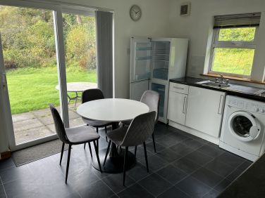 Large fitted well equipped kitchen with patio doors that open out onto the garden