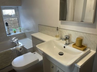First floor bathroom with bath and shower over.