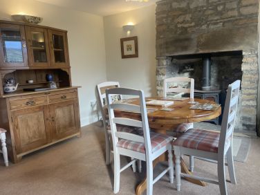 The dining room with attractive dresser & log burning stove.  The dining table extends to seat six.