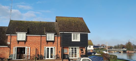 Bure Cottage with French doors open showing main river and Wroxham Bridge