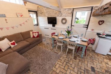 Comfy lounge area with large corner sofa and mounted TV