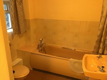 Bathroom 3 piece suite with shower and curtain over bath