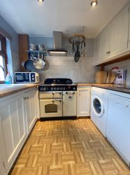 Fully stocked kitchen with tools, appliances and a wide range of pans and dishes.