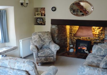 Sitting room has window seats, original inglenook with large comfortable sofa and armchairs