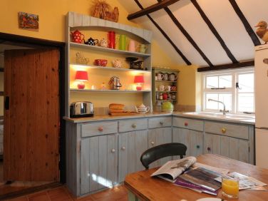 Kitchen with river, garden and woodland views; there are windows each side & door into Conservatory.