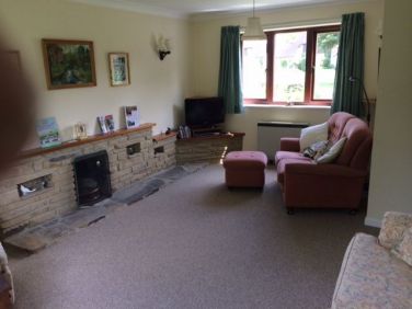 Sitting room has open fire and windows on three sides