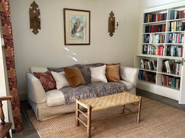 The snug with sofa books underfloor heating & woodburner.   This room is next to hall & dining area