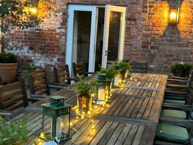 Lovely lit and pretty  outside dining area for 18 - 24  with lanterns