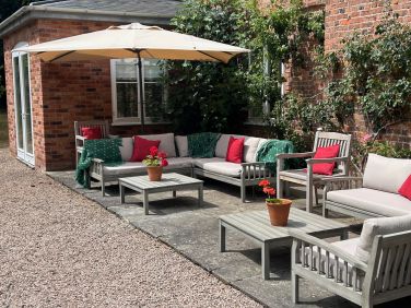 South facing terrace with sofas and chairs and parasol in the summer months