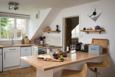 The kitchen with dishwasher, microwave, washing machine, fridge freezer and coffee machine