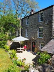 Sunny gravelled courtyard with BBQ, table and parasol