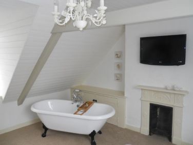 Upstairs bed room with roll top bath and wall mounted smart TV