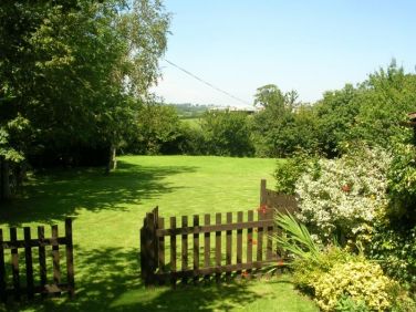 Enclosed patio garden has a gate into the meadow area.