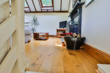 The Old Chapel upstairs showing the log burner and fireplace