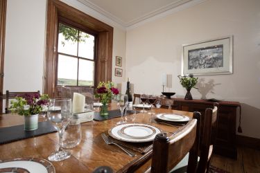 The elegant dining room with its large wooden table is perfect for all social occasions.