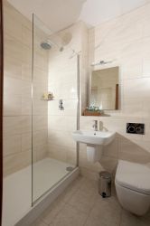 Featuring a large walk-in shower, this new modern bathroom sparkles with gleaming tiles and glass.