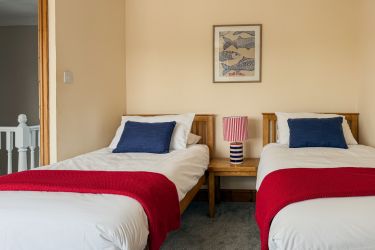 Twin beds with view of Little Haven Village in Pembrokeshire