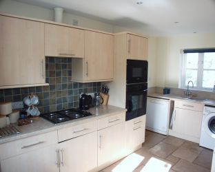 Kitchen with gas hob, microwave and oven