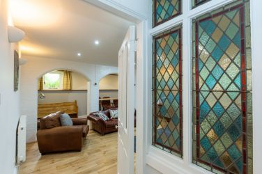 View of the basement lounge with feature stain glass windows in Fairlea Grange