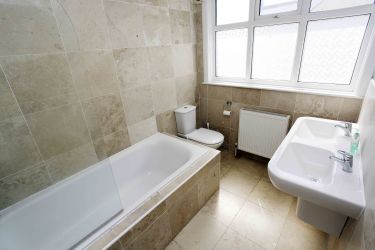 Main bathroom, with shower over bath, twin sinks and w/c