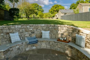 Circular seating gazing out at the Howgills at the bottom of the garden.