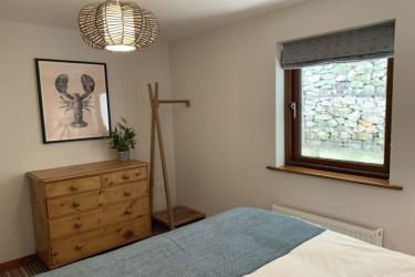 Storage in the main bedroom - chest of drawers and hanging rail