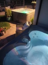 Both hot tubs at night under patio lighting. 1 or 2 hot tubs for hire