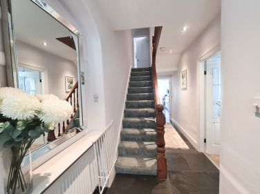 Long hall with slate flagstones and stairs to the first floor. ©Aeolian Holiday Cottage