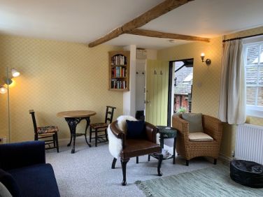 Lovely cottage living room with wood burning stove and dining area.
