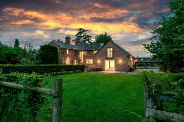 Garden Cottage on the right hand side of Monnington House at dusk.   Sleeps 18 in 9 double bedroom