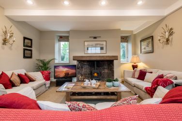 The second reception room known as The tv room with smart TV, wood burner and 3 comfy sofas