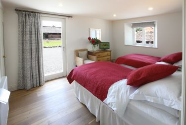 Kelmscott bedroom in Garden Cottage has en suite shower room with grab rails and lever taps