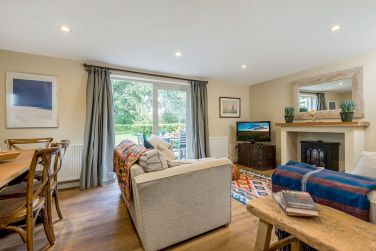 Sitting room in Garden Cottage with 2 sofas and dining area for 6 and french doors onto the garden