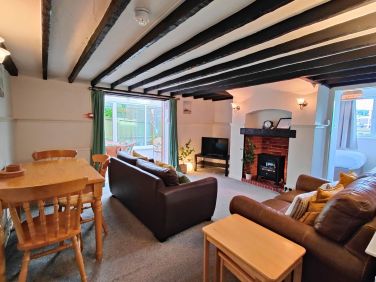 Open Plan Lounge/Dining Room with Smart TV & Patio Doors leading to the Conservatory