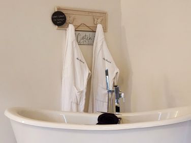 Feature bath in king-size bedroom, with fluffy robes provided
