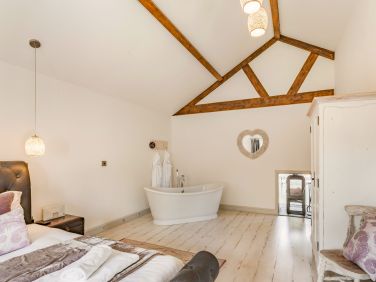 Spacious bedroom with double sided wood-burner