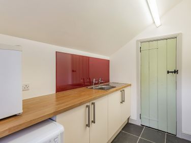 Utility room with washing machine, extra sink and freezer