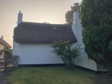 The back wall of the cottage backs directly onto the Churchyard