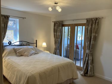 Bedroom 1 king size bed with french doors into lounge